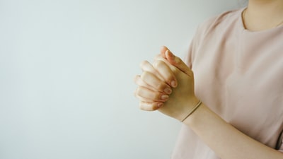 人穿着粉红色的水手领衬衫的手紧握在一起
